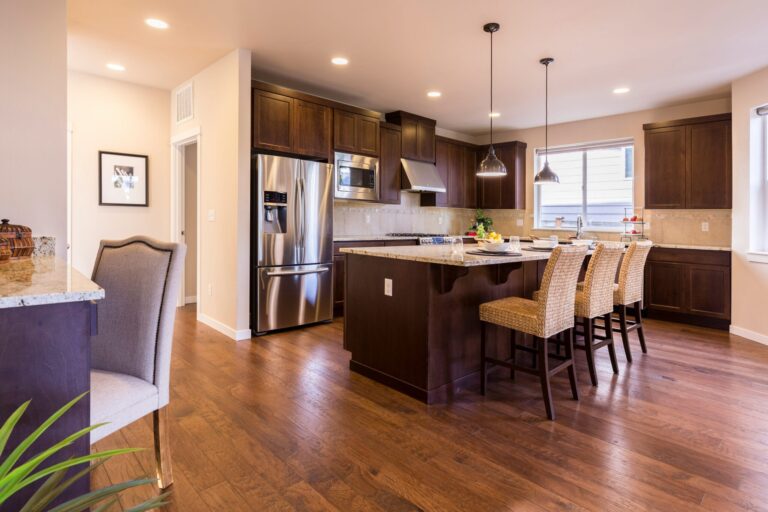 Stylish modern kitchen featuring dark wood cabinets and an island with seating